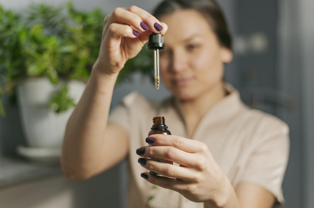 Donna con boccetta di olio essenziale tra le mani